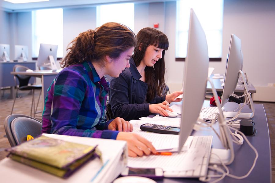 Two students work in the computer lab for their business analytics minor.