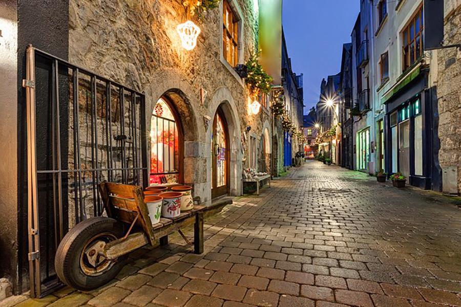 A city street in Ireland during the evening.