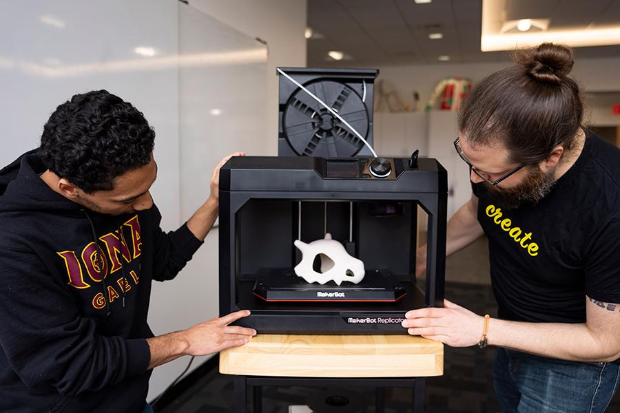 Rob Kissner and a student work with the Maker Bot.