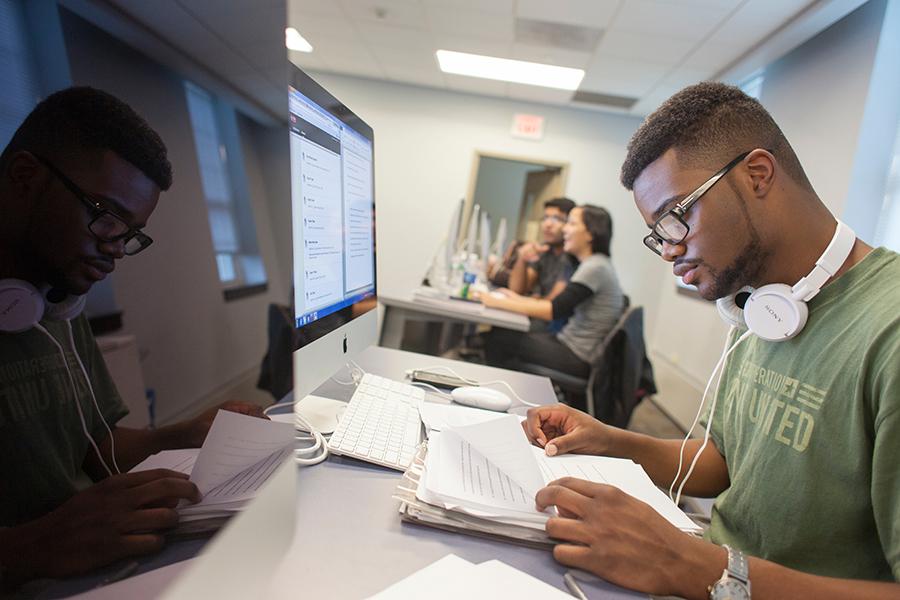 A student reads a textbook in the computer lab.