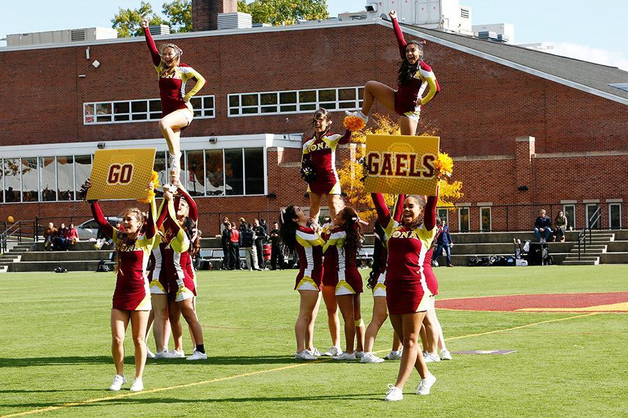 Iona cheerleading hold up Go Gaels signs on Mazzella field.