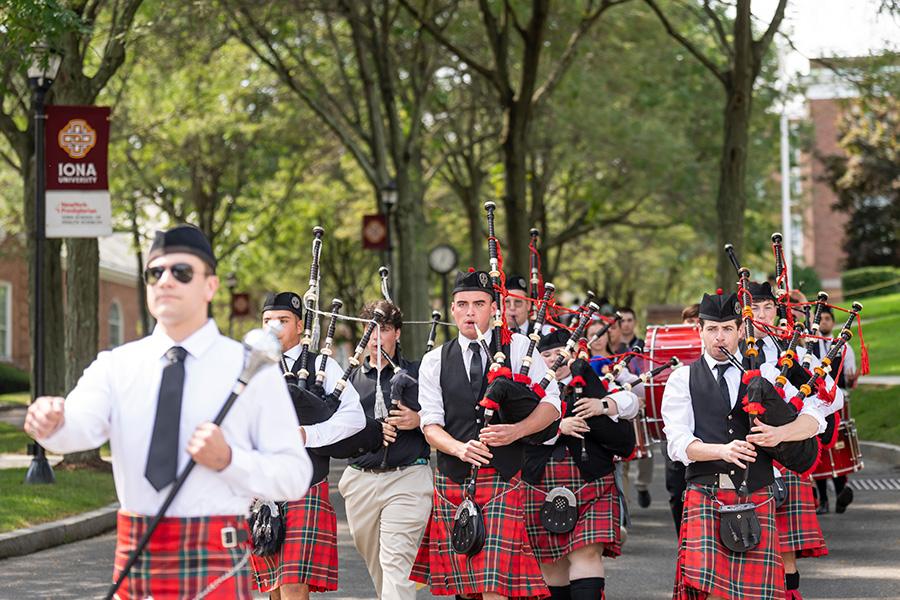 The Iona University pipe band walks down the main road on campus.