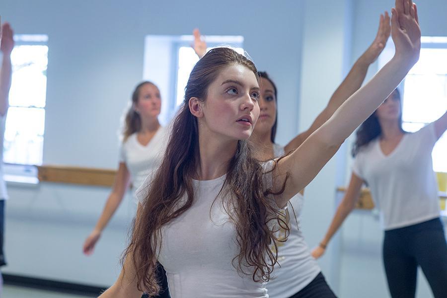 A student raises her arm during a yoga class.