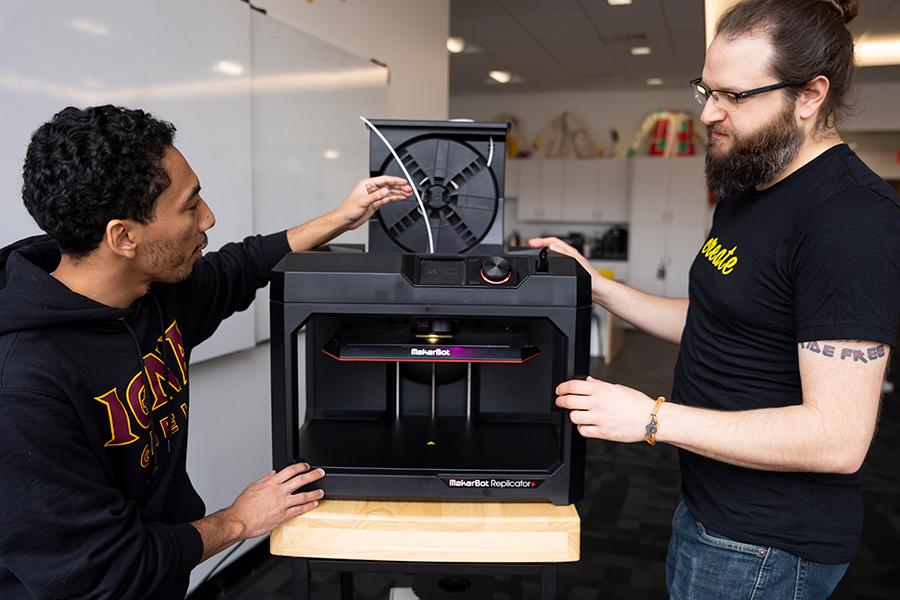 Rob Kissner and a student work with the Maker Bot.