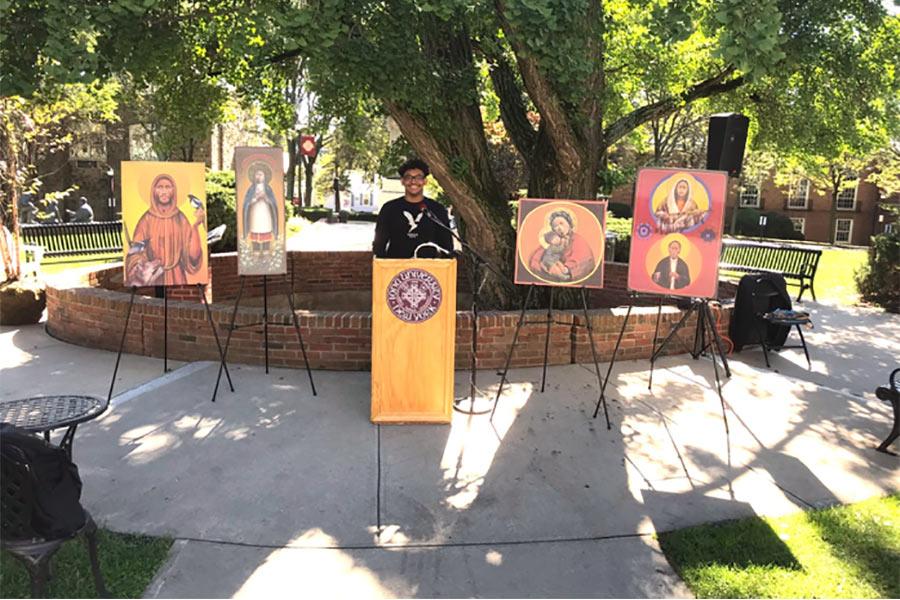 Student Fausto Rincon at podium with Icons