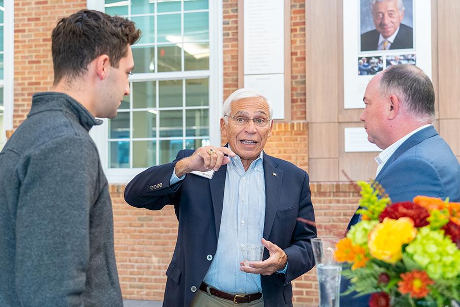 Three alumni talk at an event.