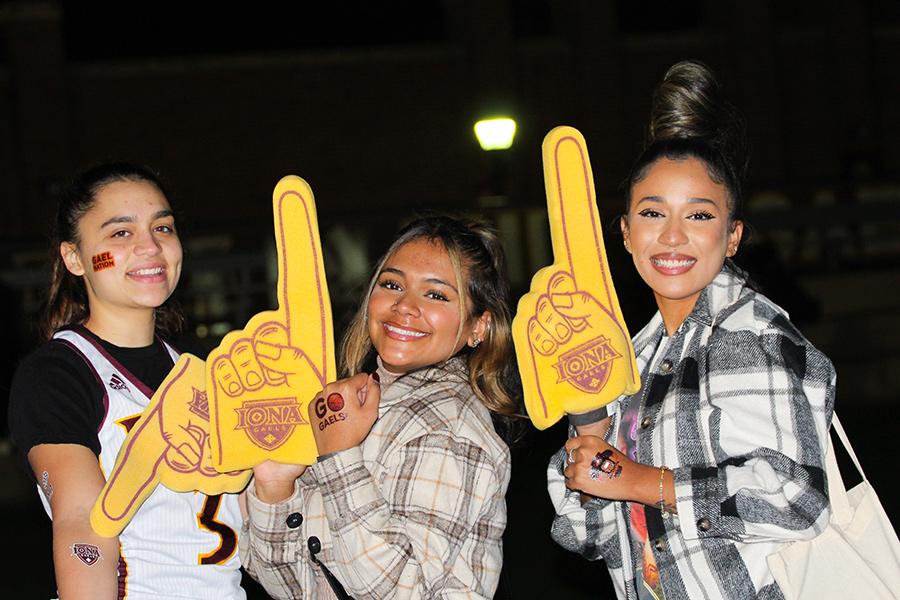 Three students hold number one foam fingers at a GaelGate party.