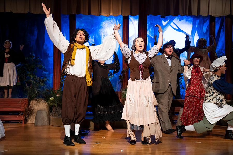 Two Iona Players cast members raise their arms in song at Into the Woods.