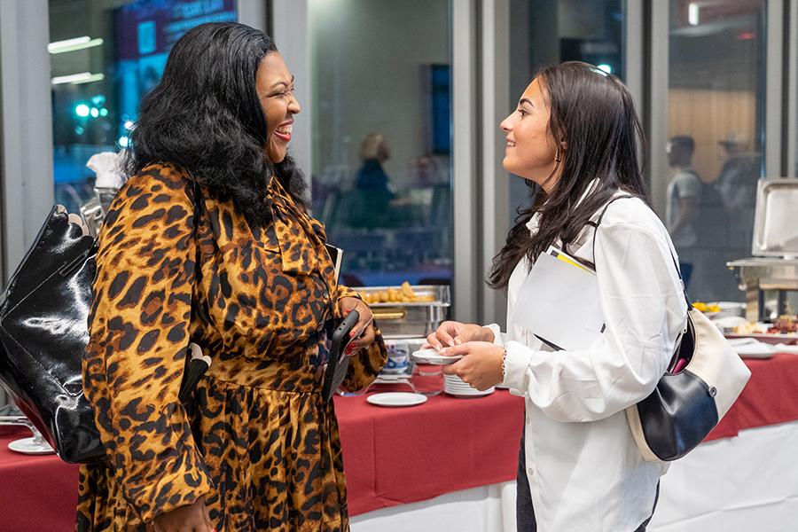 A student at the Gaels Go Further kick-off party talks with her mentor.