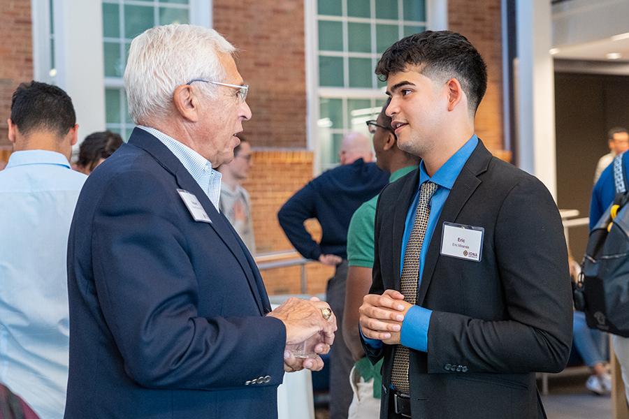 A student speaks with his mentor at the kick off event.