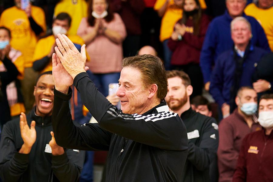 Rick Pitino applauds during a basketball game.