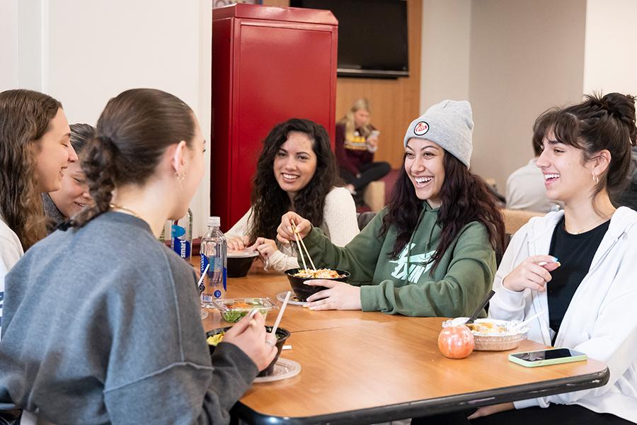 Students smile and laugh while having lunch in Vitanza Commons.