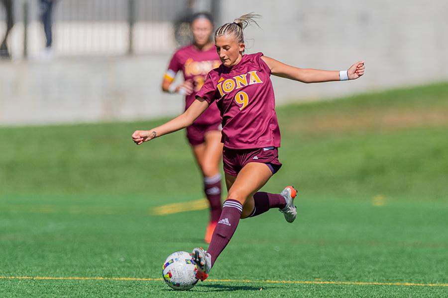 A member of the Iona women's soccer team kicks the ball down field.