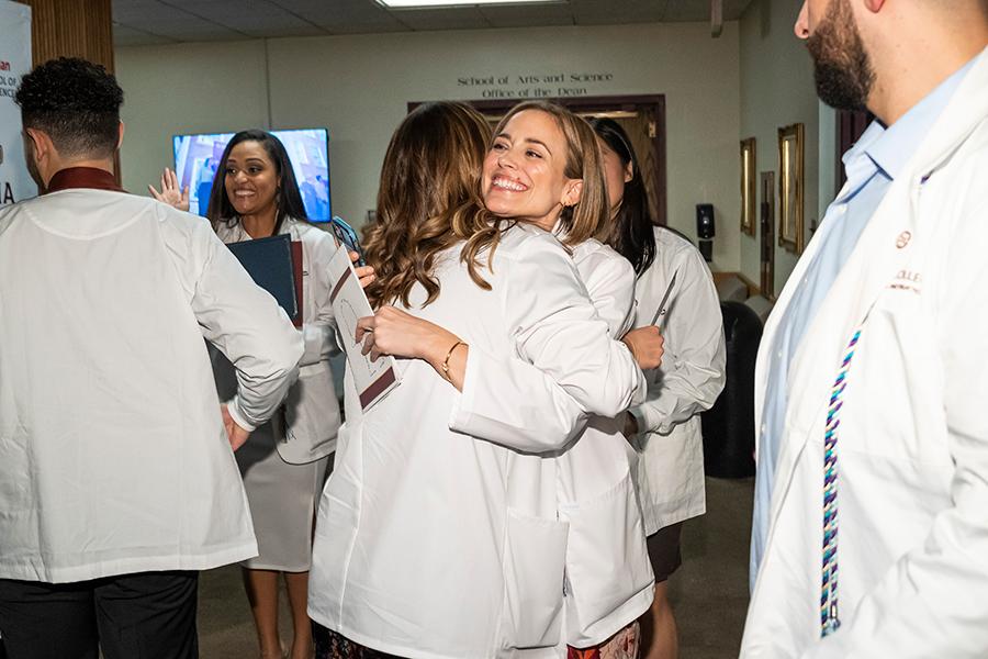 Erin Mitchell hugs her fellow nursing classmate.