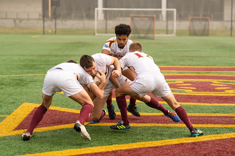 Iona men's rugby practice a play on field.