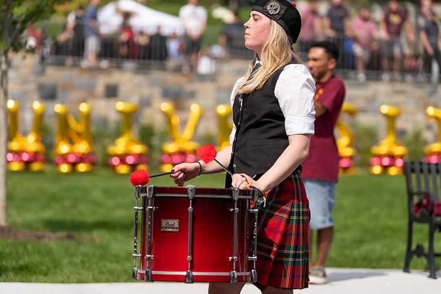 A member of the pipe band plays a drum at the Iona birthday party.