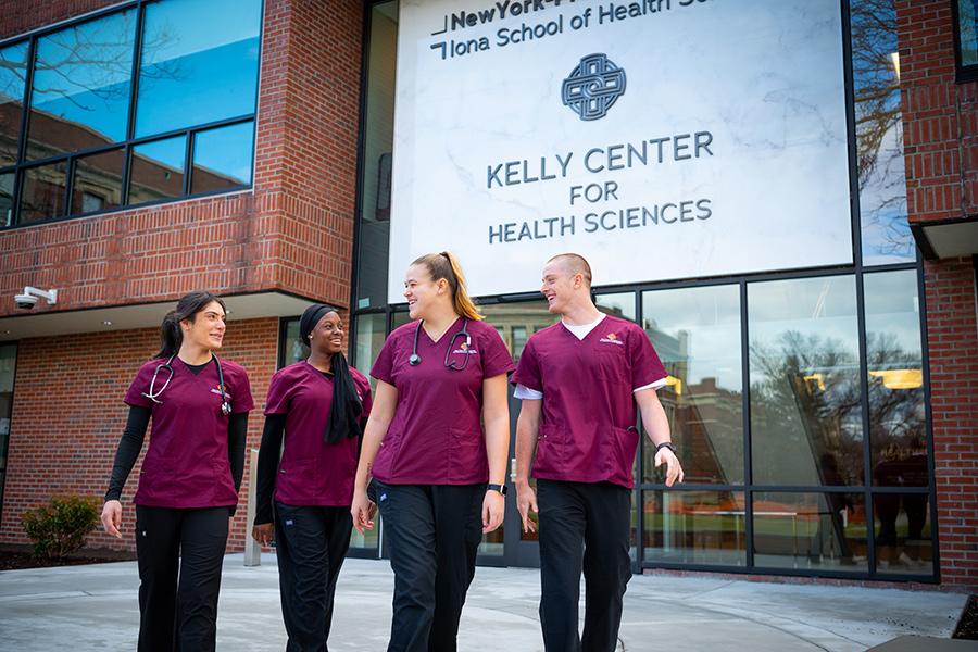 Students walk and smile outside of the Kelly Center.