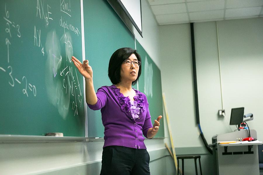 Dr. Sunghee Lee teaches and writes on the blackboard.