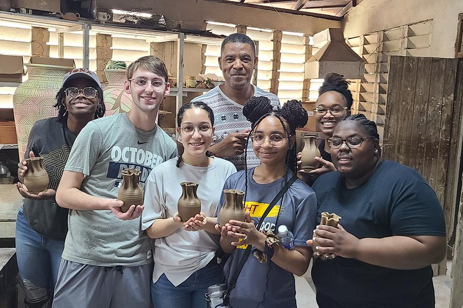 Students show their pottery works during the Jamaica service trip.