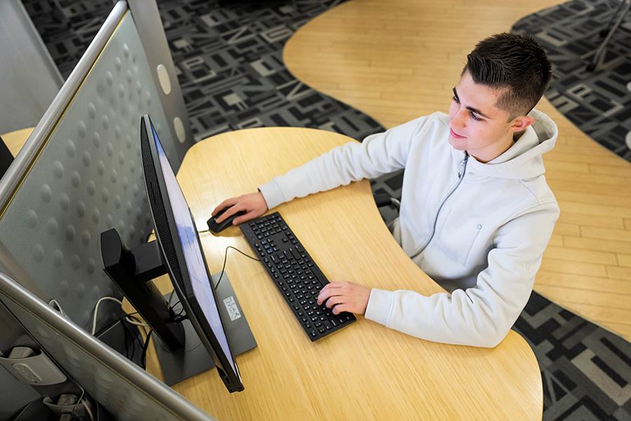 An overhead view of a student working at a desktop station.