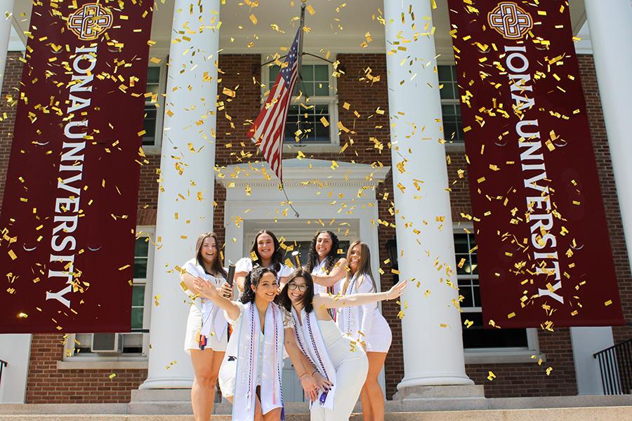 Five sorority sisters set off confetti canons outside of McSpedon.