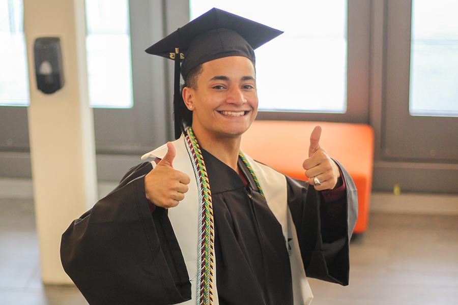 A 2023 graduate gives two thumbs up.
