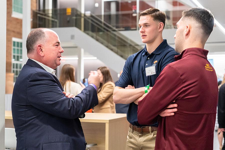 Jim Oats speaks with two mentees at the end of the year party.