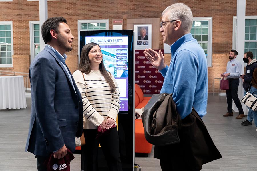 A mentor talks with two mentees.