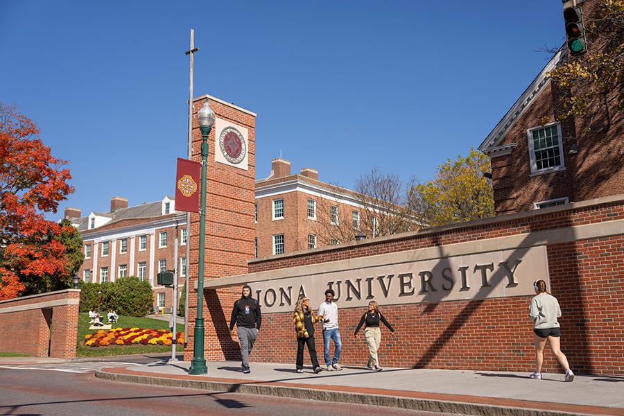 Students walk past the north avenue entrance on a sunny day.