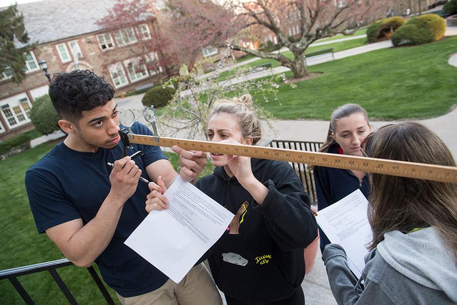 A group of students work outside in a physics class.