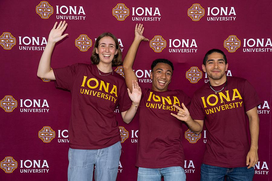 Three students in Iona shirts at the step and repeat.