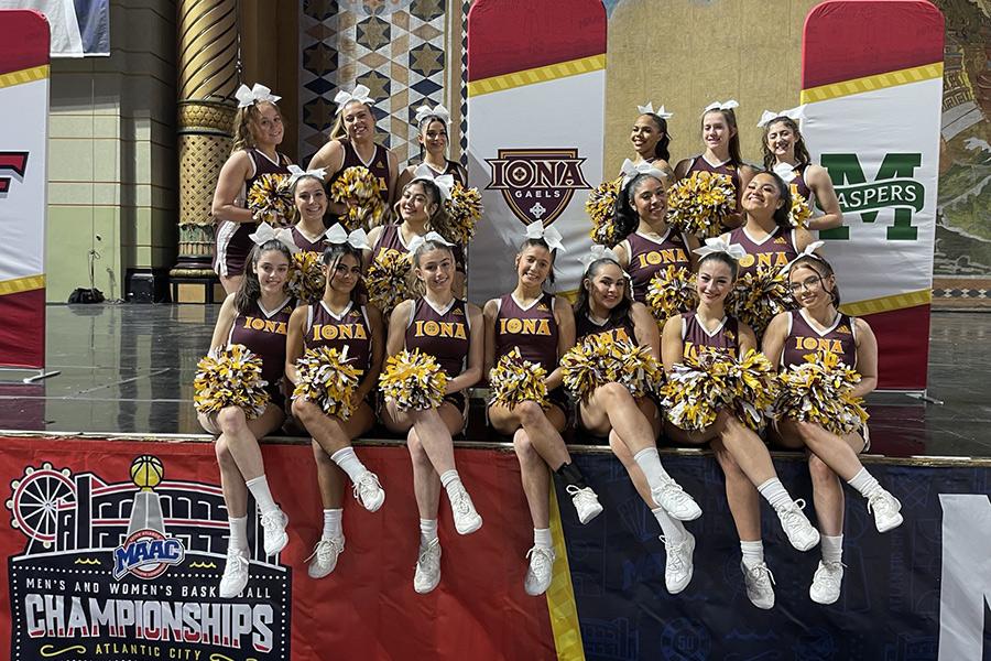 The cheer team pose on stage at the MAAC tournament.