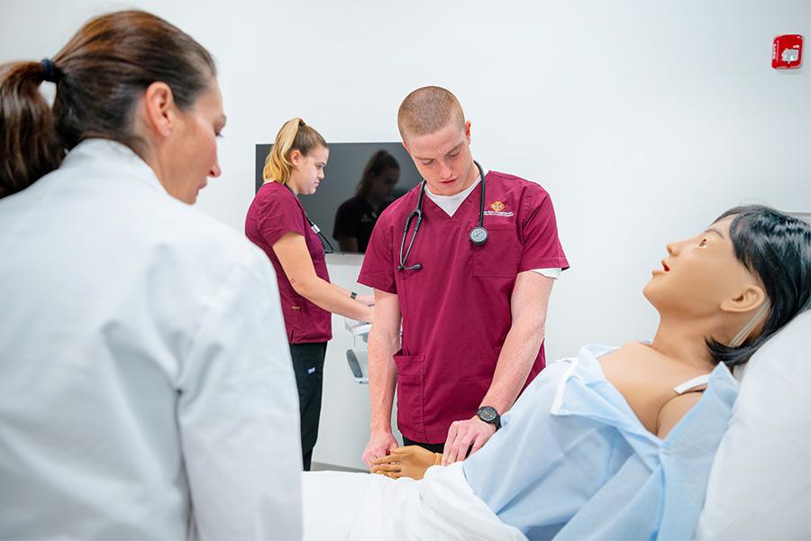 Students work in the simulation lab on mannequins.