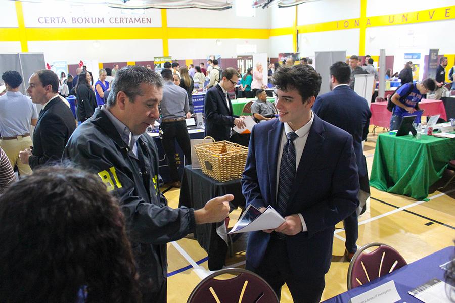 A student talks with an FBI agent at the career fair.