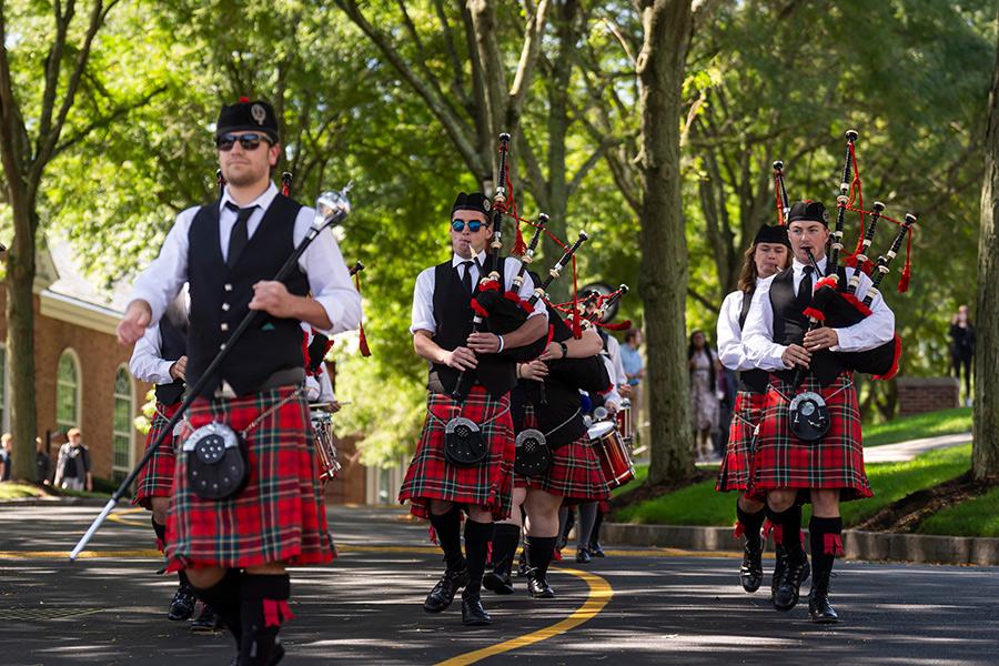 The Iona Pipers play walking down main street on campus.