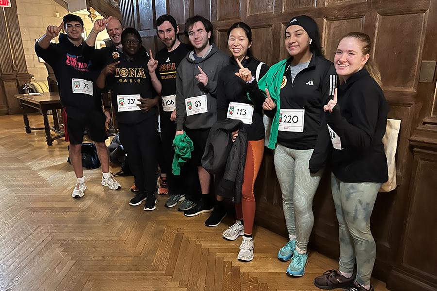 The co-ed running team giving a number 1 sign.