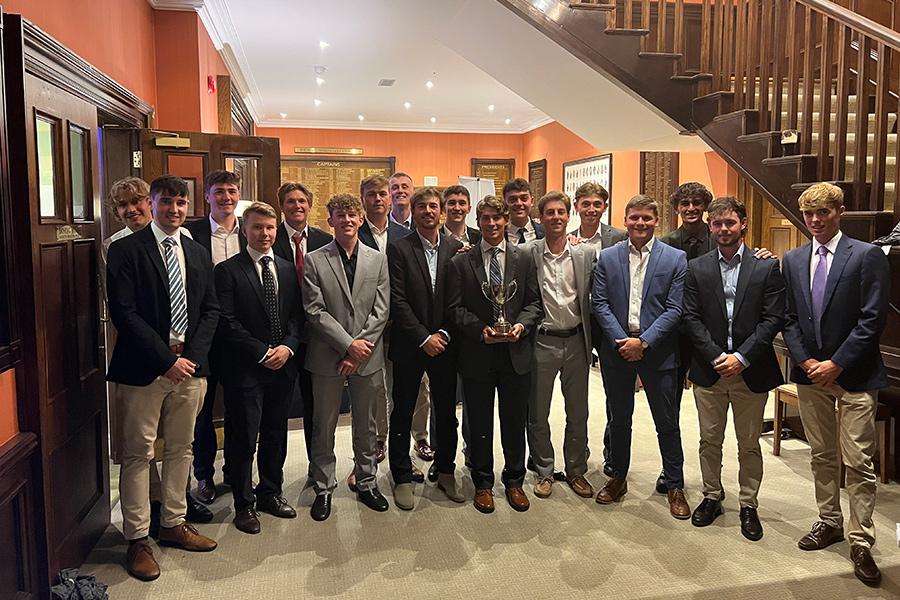 The golf team displaying a trophy.