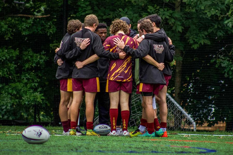The rugby team huddles up at a game.