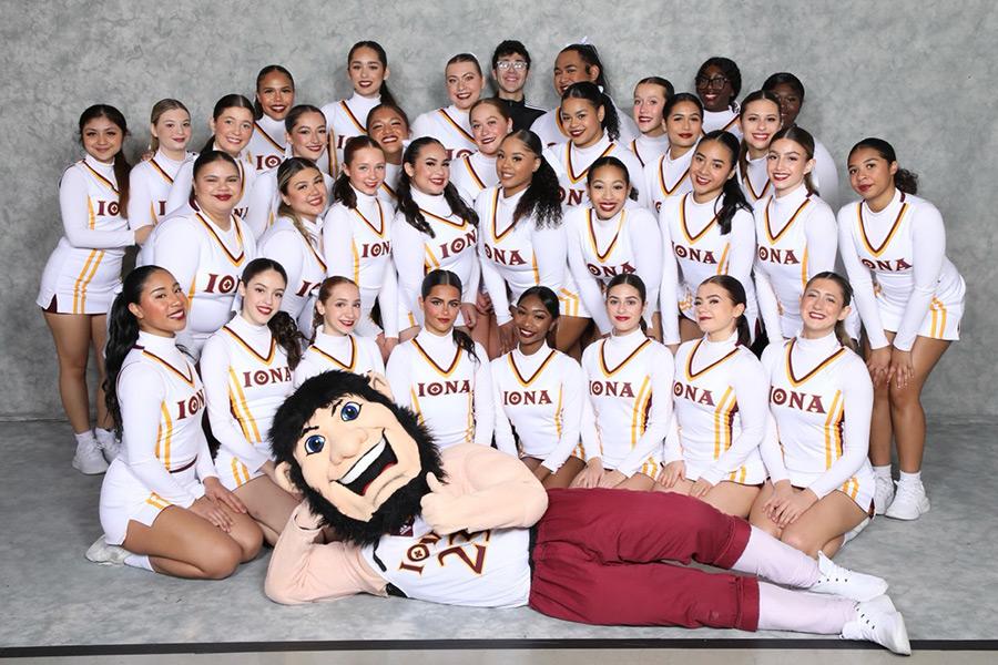 The cheer team poses with Killian laying across the floor.