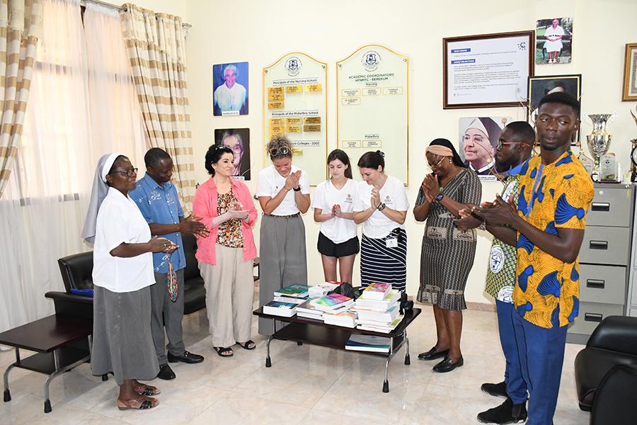 Saying a prayer over the donated nursing textbooks Shery Watson, Ph.D., brought.