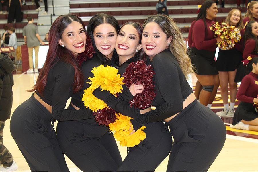 Four members of the dance team smile together.