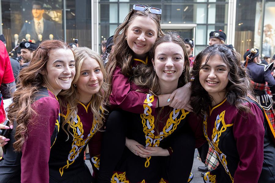 Five members of Irish dance smile together.