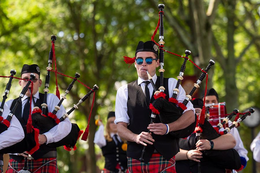 The pipers play as they walk down the main street on campus.