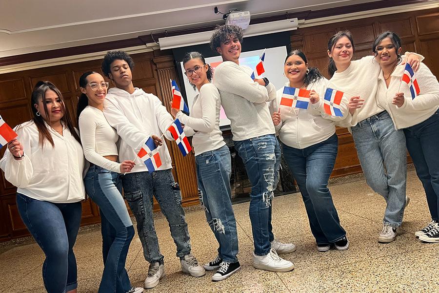 Bailando con Sazón members holding the flag from the Dominican Republic.