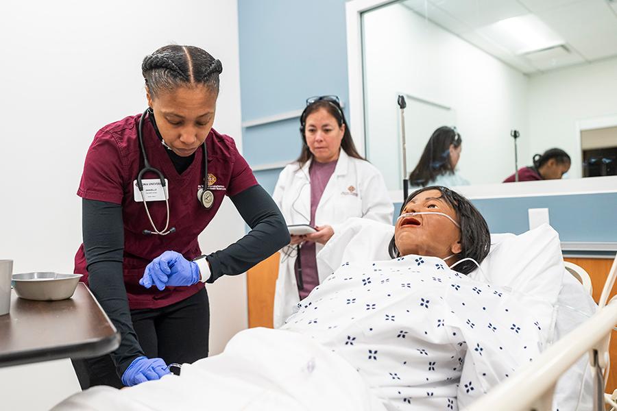 A nursing education major practicing rounds with her professor.