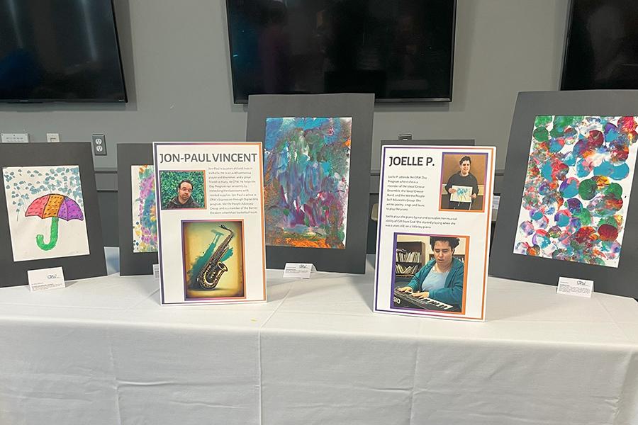 A table at the CPW talent showcase with bios of the artists and their paintings.