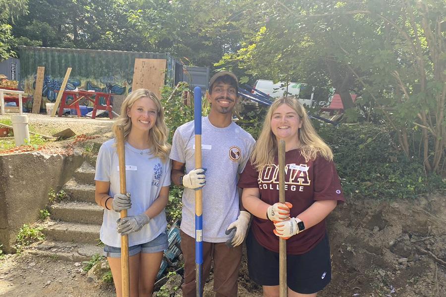 Get Moving students cleaning up a yard.