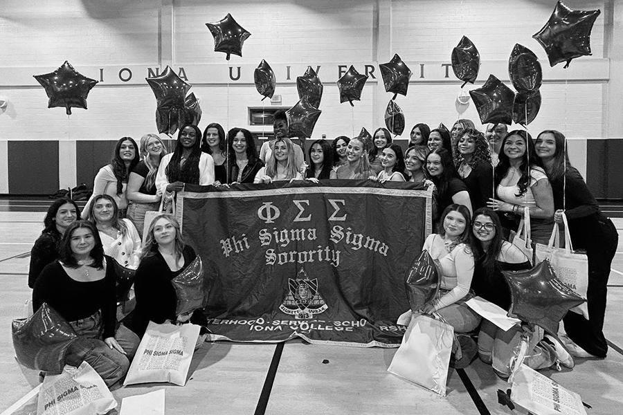 Members of Phi Sig with a banner and balloons in Mulcahy.