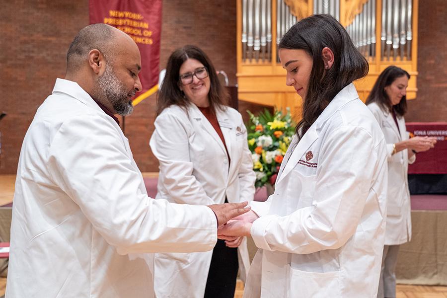 A professor and a student at the white coat ceremony.
