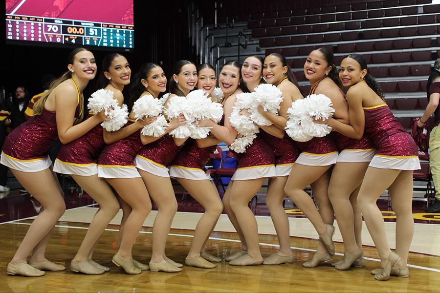 Dance team members huddling together for a group photo after the Iona Men's Basketball Game in the Mulcahy Gymnasium.